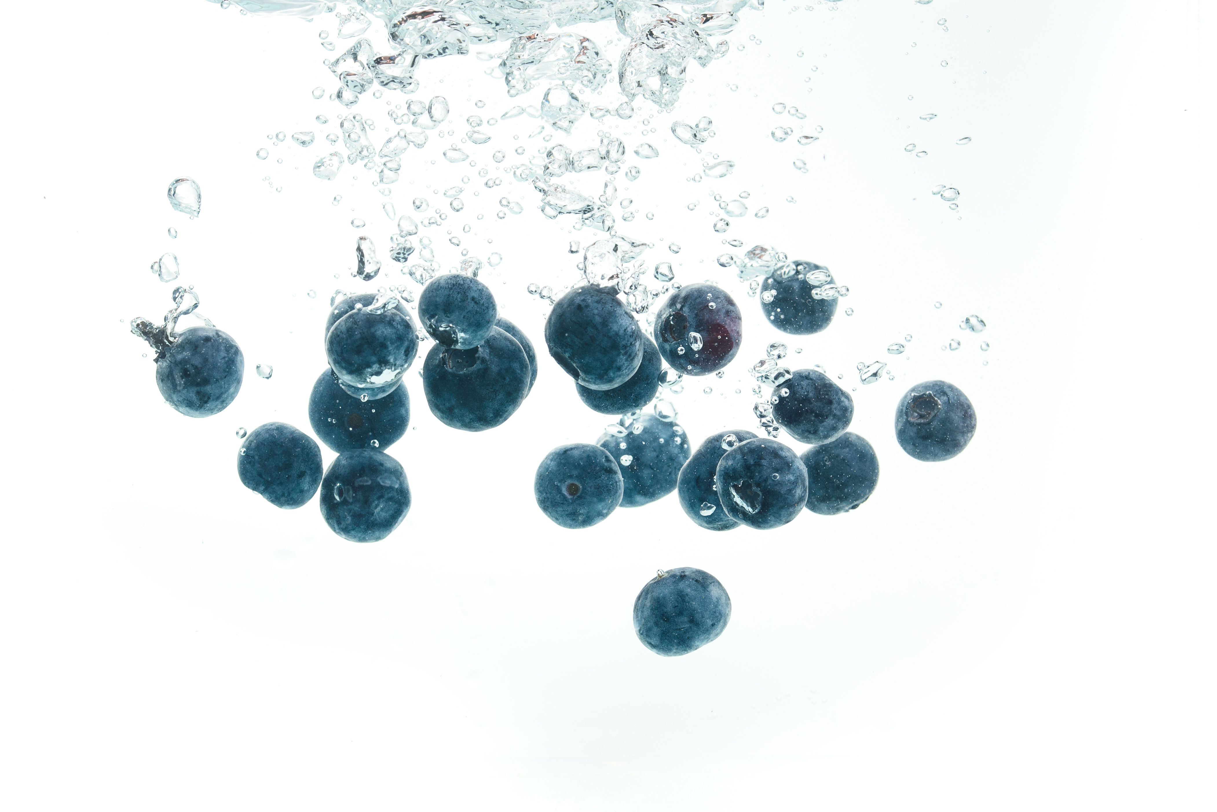 blueberries-falling-into-water-on-white-background-9PSMJUB.jpg